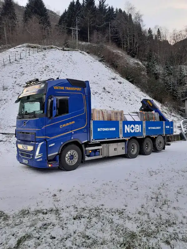 Moderne betongbil for transport av betongvarer i snødekt landskap.